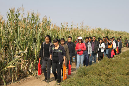 Farmers visit the farmland in Songshan District of Chifeng City of north China's Inner Mongolia Autonomous Region, September 25, 2009.