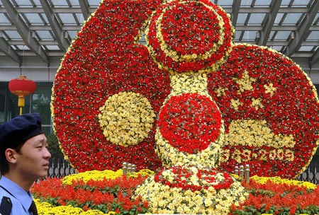A security man stands in front of a mosaiculture design in Beijing, capital of China, September 25, 2009.