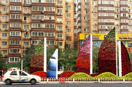 A car passes a mosaiculture design in Beijing, capital of China, September 25, 2009. 