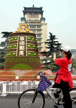 A woman takes photos of a mosaiculture design in Beijing, capital of China, September 25, 2009. 