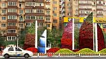 A car passes a mosaiculture design in Beijing, capital of China, September 25, 2009.