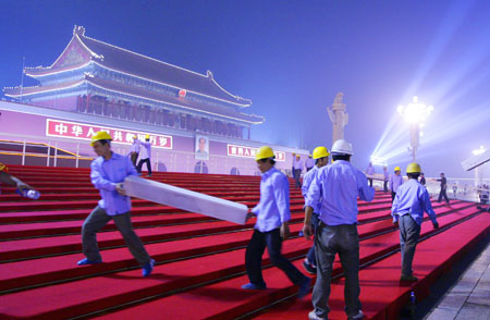 Workers assemble the temporary reviewing stands on the both sides of Tiananmen rostrum for China&apos;s 60th National Day celebrations in Beijing, capital of China, September 25, 2009.