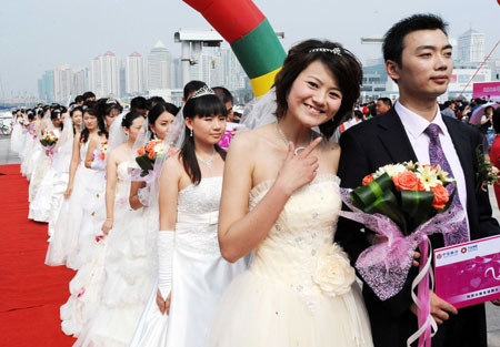 A bride smiles during a mass wedding in Qingdao, east China&apos;s Shandong Province, September 27, 2009. The mass wedding, under the theme of &apos;blessing the homeland&apos;, was attended by 60 couples. The 60th anniversary of the founding of the People&apos;s Republic of China will be celebrated on October 1.
