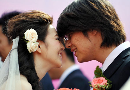 A groom prepares to kiss his bride during a mass wedding in Qingdao, east China&apos;s Shandong Province, September 27, 2009. The mass wedding, under the theme of &apos;blessing the homeland&apos;, was attended by 60 couples. The 60th anniversary of the founding of the People&apos;s Republic of China will be celebrated on October 1. 