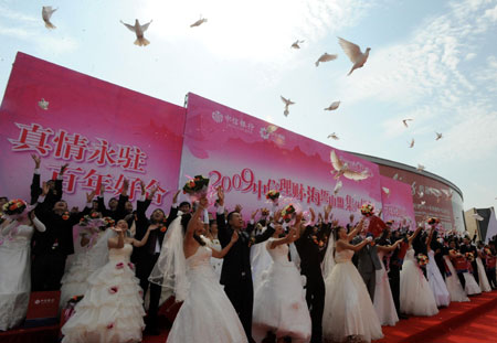 New couples release the pigeons during a mass wedding in Qingdao, east China&apos;s Shandong Province, September 27, 2009. The mass wedding, under the theme of &apos;blessing the homeland&apos;, was attended by 60 couples. The 60th anniversary of the founding of the People&apos;s Republic of China will be celebrated on October 1.