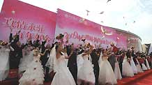 New couples release the pigeons during a mass wedding in Qingdao, east China's Shandong Province, September 27, 2009. The mass wedding, under the theme of 'blessing the homeland', was attended by 60 couples. The 60th anniversary of the founding of the People's Republic of China will be celebrated on October 1.