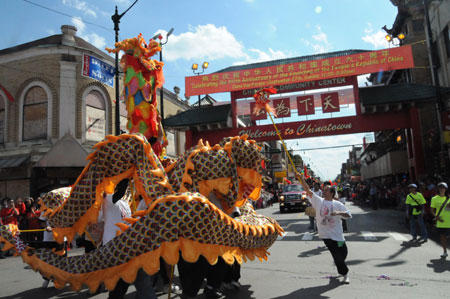 Performers play dragon dance during a parade in Chinatown of Chicago, the United States, on September 27, 2009. The parade was held here on Sunday to celebrate the upcoming 60th anniversary of the founding of the People's Republic of China.
