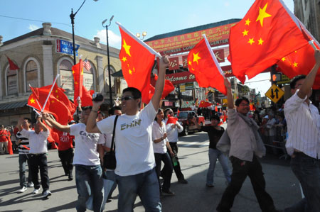 People hold national flags of the People's Republic of China during a parade in Chinatown of Chicago, the United States, on September 27, 2009. The parade was held here on Sunday to celebrate the upcoming 60th anniversary of the founding of the People's Republic of China.