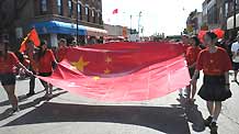 Girls hold the national flag of the People's Republic of China during a parade in Chinatown of Chicago, the United States, on September 27, 2009. The parade was held here on Sunday to celebrate the upcoming 60th anniversary of the founding of the People's Republic of China.