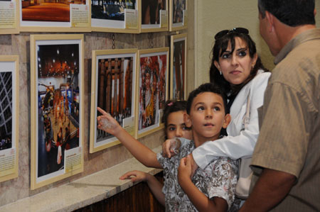 Visitors watch a photo exhibition held to celebrate the upcoming 60th anniversary of the founding of the People's Republic of China, in Tunis, Tunisia, September 26, 2009.