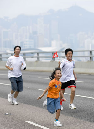 Local residents walk on the eastern corridor of Hong Kong, south China, on September 27, 2009.