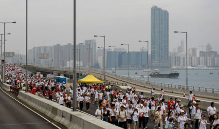 Local residents walk on the eastern corridor of Hong Kong, south China, on September 27, 2009.