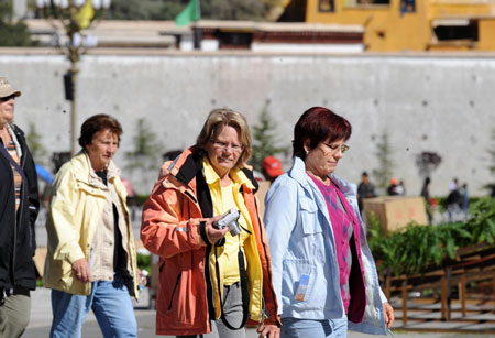 Foreign tourists walk in the street in Lhasa, capital of southwest China's Tibet Autonomous Region, on September 27, 2009. 