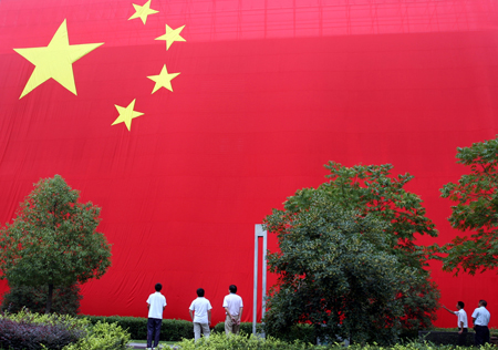 People look at a huge Chinese national flag with the area of 960 square meters, which is made to mark the upcoming 60th anniversary of the founding of the People's Republic of China, in Changxing, a city of east China's Zhejiang Province, September 28, 2009.