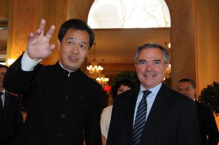 Chinese ambassador to France Kong Quan (L) welcomes French National Assembly Speaker Bernard Accoyer during a reception held at a garden in Paris, capital of France, on September 28, 2009.