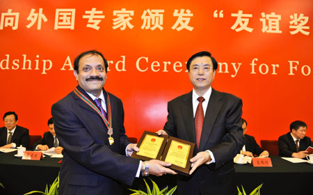 Chinese Vice Premier Zhang Dejiang (R) confers a medal and certificate to a foreign expert at the Friendship Award Ceremony for Foreign Experts at the Great Hall of the People in Beijing, capital of China, Sept. 29, 2009. Chinese government on Tuesday conferred the Friendship Award, the country's highest award for foreign experts, to 100 foreigners for their contribution to its economic and social development. Chinese Vice Premier Zhang Dejiang gave a medal and certificate to each of 100 experts from 28 different countries at the ceremony.