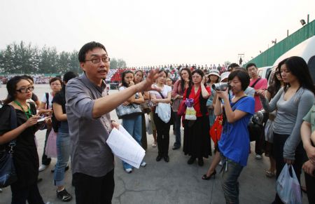 Photo taken on September 3, 2009 shows Jia Ding, executive chief director of an evening party marking the 60th anniversary of the founding of the People&apos;s Republic of China, exchanges views with staff members in Beijing. 