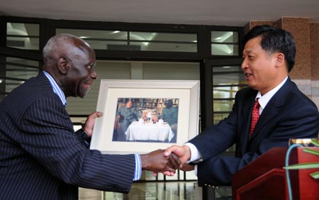 Chinese Ambassador to Zambia Li Qiangmin (R) presents a gift to a special representative of former president of Zambia Kenneth David Kaunda during a reception to celebrate the 60th anniversary of the founding of the People's Republic of China, in Lusaka, capital of Zambia, on September 29, 2009.