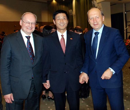 Chinese ambassador to Lithuania Tong Mingtao (C) holds hands with Lithuanian Prime Minister Andrius Kubilius (R), during a reception to celebrate the 60th anniversary of the founding of the People's Republic of China, in Vilnius, capital of Lithuania, on September 29, 2009. 