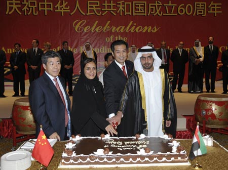 Chinese ambassador to the United Arab Emirates (UAE) Gao Yusheng (2nd R) and guests cut a cake during a reception to celebrate the 60th anniversary of the founding of the People's Republic of China, in Abu Dhabi, capital of the UAE, on September 29, 2009.