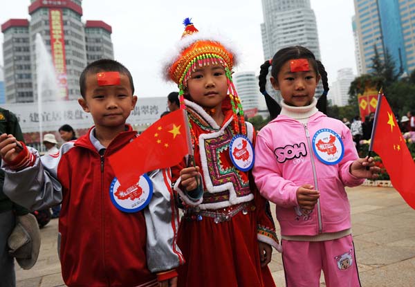 Three children who were born on Oct. 1 pose for a group photo in Kunming, southwest China Yunnan Province, October 1, 2009. Sixty people who were born on Oct. 1 gathered in Kunming to spend their birthday together while celebrating the 60th anniversary of the founding of the People&apos;s Republic of China on Thursday.