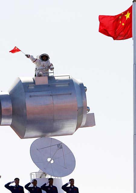 Chinese taikonaut Zhai Zhigang (top), dressed in his space suit, emerges from a simulated Shenzhou-7 capsule and waves a national flag, recreating his historical moment on September 27, 2008, during the parade of the celebrations for the 60th anniversary of the founding of the People&apos;s Republic of China, on Chang&apos;an Avenue in central Beijing, capital of China, October 1, 2009.