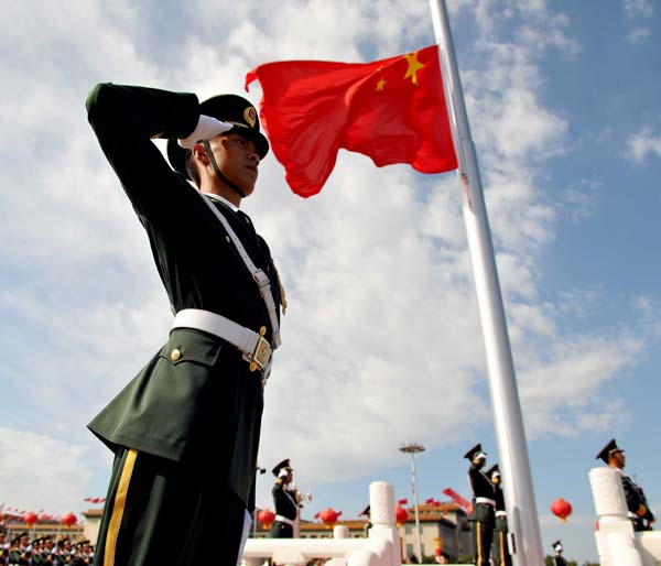 Guards of the national flag salute during the flag-raising ceremony at the start of the celebrations for the 60th anniversary of the founding of the People&apos;s Republic of China, on the Tian&apos;anmen Square in central Beijing, capital of China, October 1, 2009.