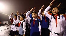 Young Pioneer performers of the National Day celebrations practise salute while gathering at the Workers Stadium in the early morning in Beijing, on October 1, 2009. China will celebrate on October 1 the 60th anniversary of the founding of the People's Republic of China.