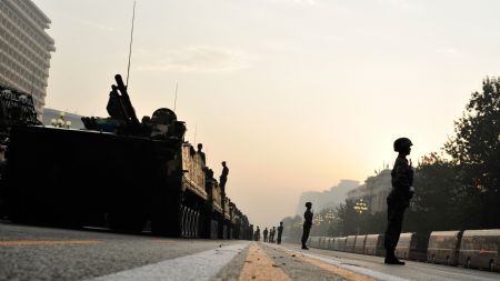 Soldiers guard vehicles which will take part in the celebrations for the 60th anniversary of the founding of the People's Republic of China, in Beijing, capital of China, Oct. 1, 2009. (Xinhua/Yang Guang)