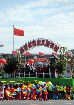 A float surrounded by people takes part in a parade of the celebrations for the 60th anniversary of the founding of the People&apos;s Republic of China, on Chang&apos;an Street in central Beijing, capital of China, Oct. 1, 2009. (Xinhua/Xu Yu)