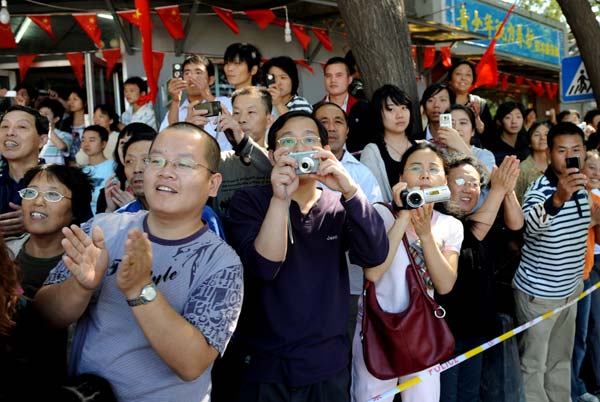 Local residents gather to welcome people taking part in a parade of the celebrations for the 60th anniversary of the founding of the People's Republic of China, in Beijing, capital of China, Oct. 1, 2009. (Xinhua/Tao Ming) 