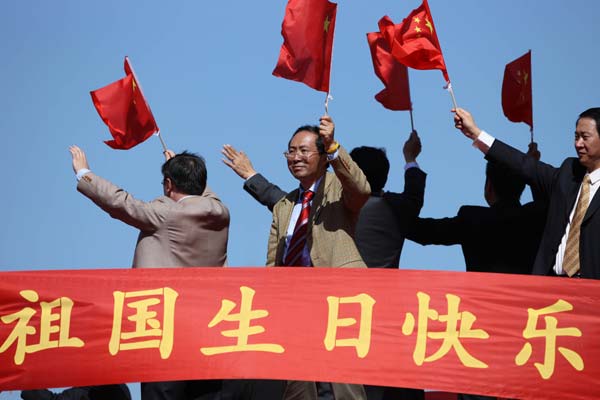 People wave national flags in a parade of the celebrations for the 60th anniversary of the founding of the People's Republic of China, on Chang'an Street in central Beijing, capital of China, Oct. 1, 2009. (Xinhua/Lu Mingxiang) 