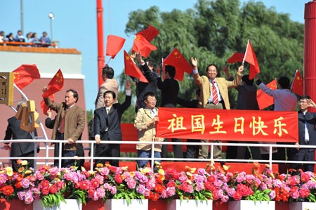 People wave national flags on a float in a parade of the celebrations for the 60th anniversary of the founding of the People&apos;s Republic of China, on Chang&apos;an Avenue in central Beijing, capital of China, Oct. 1, 2009. (Xinhua/Jin Liangkuai)