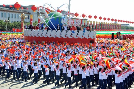 A float featuring "one world" takes part in a parade of the celebrations for the 60th anniversary of the founding of the People