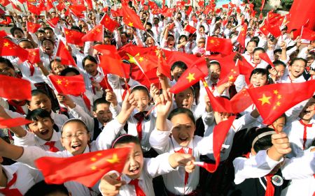 Pupils wave Chinese national flags during a celebration for the 60th anniversary of the founding of the People's Republic of China, in Lianyungang, east China's Jiangsu Province, Sept. 30, 2009. (Xinhua/Wang Jianmin)