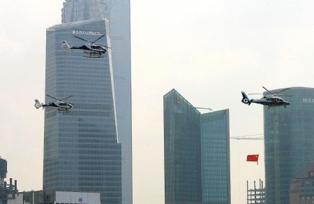 Helicopters carrying national flags fly around the oriental pearl TV tower in Shanghai, China, Oct. 2, 2009. China celebrated the 60th anniversary of the founding of the People's Republic of China on Thursday. (Xinhua/Chen Fei)