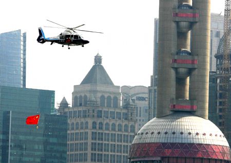 Helicopters carrying national flags fly around the oriental pearl TV tower in Shanghai, China, Oct. 2, 2009.(Xinhua/Chen Fei)