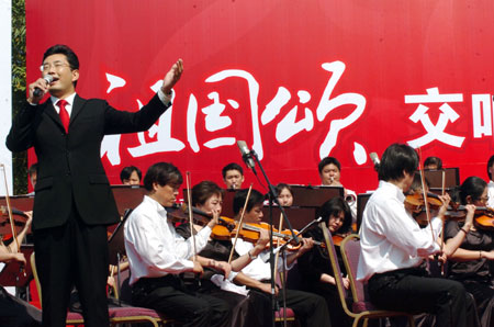 A performer elocntes emotionally during a symphonic poem recitation show of Ode to Homeland, an outdoor public performance at the side of the West Lake with the musical obbligato by a symphony orchestra, in close range with the audience, in Hangzhou, capital of east China's Zhejiang Province, Oct. 2, 2009. (Xinhua/Shi Jianxue) 