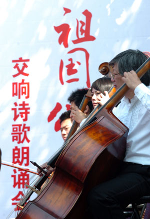 Performers of violoncello play melodious tune during a symphonic poem recitation show of Ode to Homeland, an outdoor public performance at the side of the West Lake with the musical obbligato by a symphony orchestra, in close range with the audience, in Hangzhou, capital of east China's Zhejiang Province, Oct. 2, 2009. (Xinhua/Shi Jianxue)