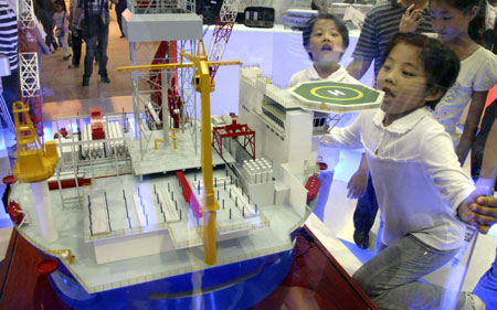 Kids view the model of deep sea oil drilling and storage platform at the Progressive Jiangsu -- Grand Exposition of Achievements in Celebration of the 60th Anniversary of the Founding of the People's Republic of China, at the Nanjing International Expo Center, in Nanjing City, capital of east China's Jiangsu Province, Oct. 2, 2009. (Xinhua/Dong Jinlin)