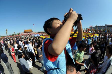 A boy takes photographs on the Tian'anmen Square in central Beijing, capital of China, on Oct. 3, 2009.(Xinhua/Yang Zongyou)