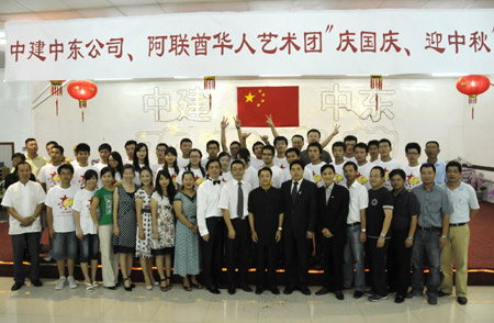 Workers with the China State Construction Engineering Corporation (CSCEC) pose for a photo during an evening party held in Dubai of UAE, October 3, 2009. An evening party was held on Saturday in Dubai to celebrate the Chinese Mid-Autumn Festival. 
