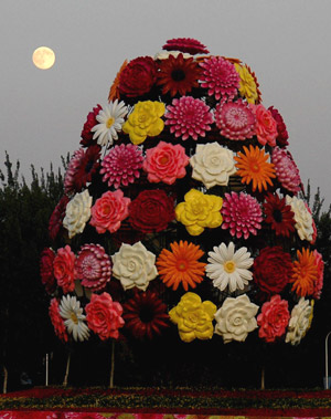 Photo taken on Oct. 3, 2009 shows a huge parterre of the seventh China Flower Expo with the backdrop of a full moon in the sky, in Shunyi District of Beijing, capital of China. 