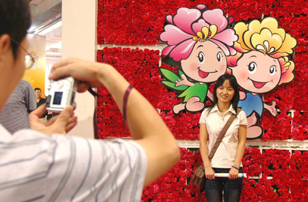 A girl poses for photos at the exhibition hall of the seventh China Flower Expo in Shunyi District of Beijing, capital of China, October 3, 2009.