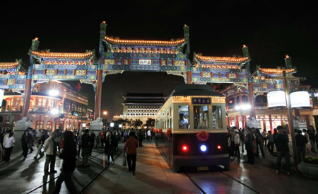 A 'Dangdang car', the old-fashioned trolley car, runs on Qianmen Street, one of the old commercial areas of Beijing, capital of China, October 3, 2009. The reopened Qianmen Street attracted a lot of tourists during the National Day holidays, which overlaps the traditional Mid-Autumn Festival this year.