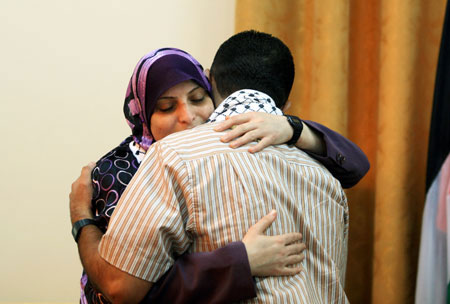 The newly-freed prisoner Rawda Habib (L), who was supposed to be freed but Israel postponed her release to Sunday due to Jewish holidays, embraces with her husband in Gaza, October 4, 2009. 