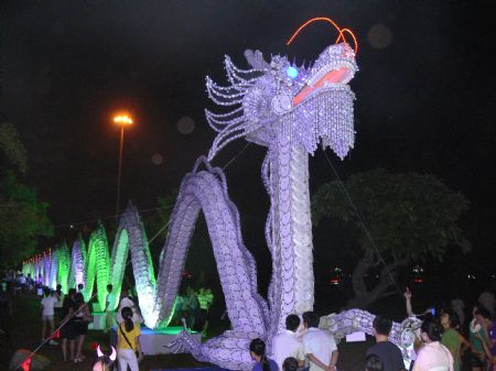 Tourists view a lantern group in the shape of dragon, a traditional symbol of luck, auspiciousness and prosperity, during a lantern show in Haikou, capital of south China&apos;s Hainan Province, Oct. 5, 2009. The lantern show was held at the Wanlu Garden in Haikou to greet the 60th anniversary of the founding of the People&apos;s Republic of China. 