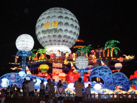 Tourists take pictures of lantern group with the theme of "international tourism island" during a lantern show in Haikou, capital of south China