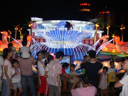 Tourists take pictures of lantern group with the theme of &apos;asian symbol&apos; during a lantern show in Haikou, capital of south China&apos;s Hainan Province, October 5, 2009. The lantern show was held at the Wanlu Garden in Haikou to greet the 60th anniversary of the founding of the People&apos;s Republic of China. 