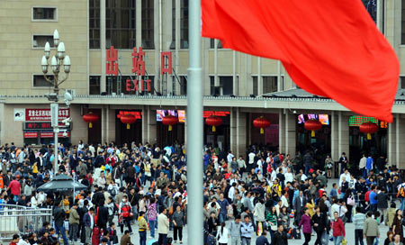 Passengers walk out of Beijing Railway Station in Beijing, capital of China, October 7, 2009. As the National Day holidays are about to end, the railway transportation witnessed a travel peak all over the nation. 